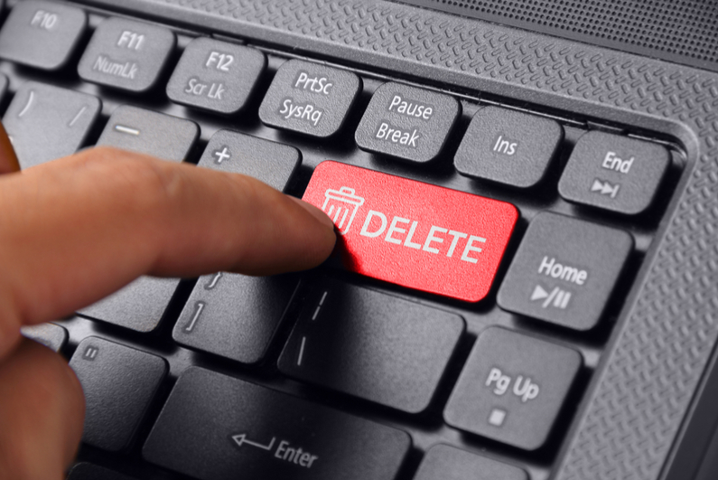 Image of a finger pressing DELETE on a laptop keyboard