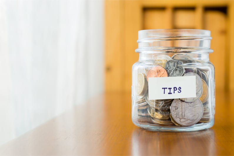 Glass bank with many world coins and TIPS label