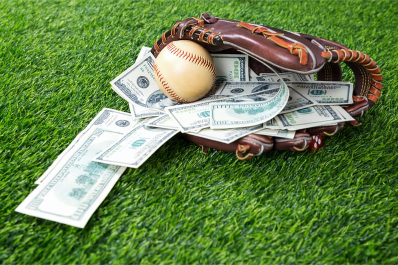 Close up of baseball in a Glove with dollar bills in concept of getting money with bets in baseball