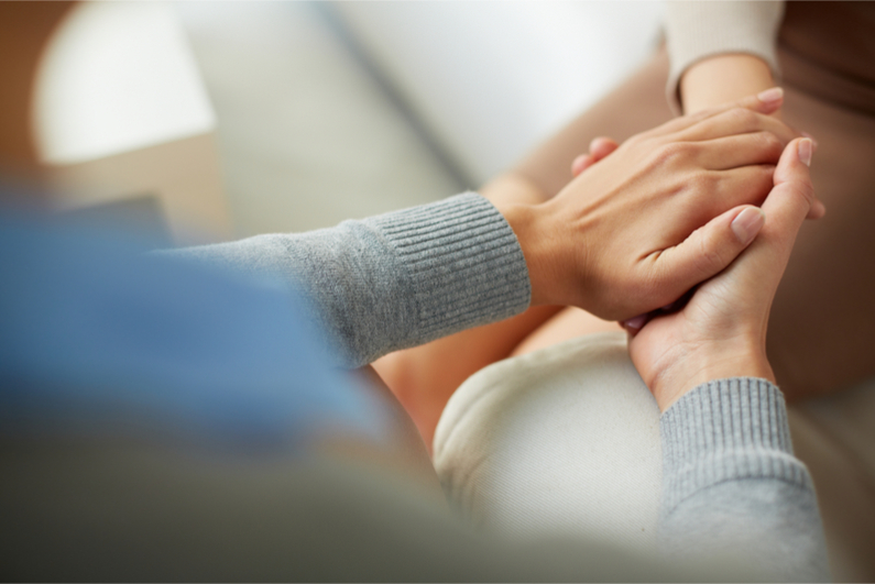 Close-up of psychiatrist hands together holding palm of her patient