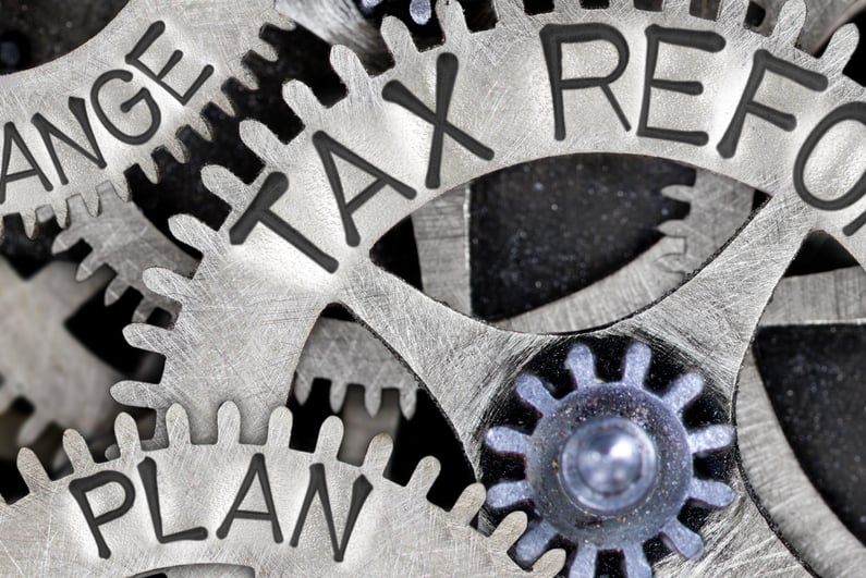 Macro photo of tooth wheel mechanism with TAX REFORM, COLLECT, CHANGE, PLAN, RATE and IMPROVE words imprinted on metal surface