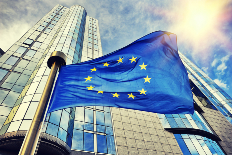EU flag waving in front of European Parliament building in Brussels, Belgium