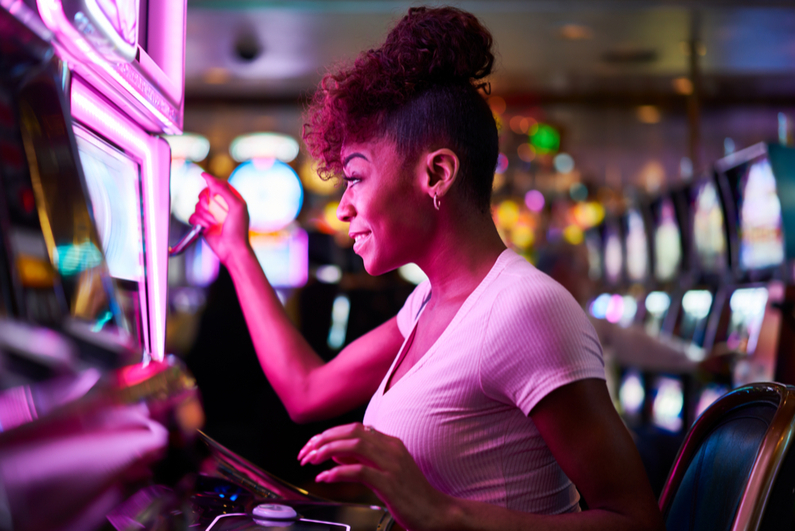 Gappy woman gambling at casino playing slot machine