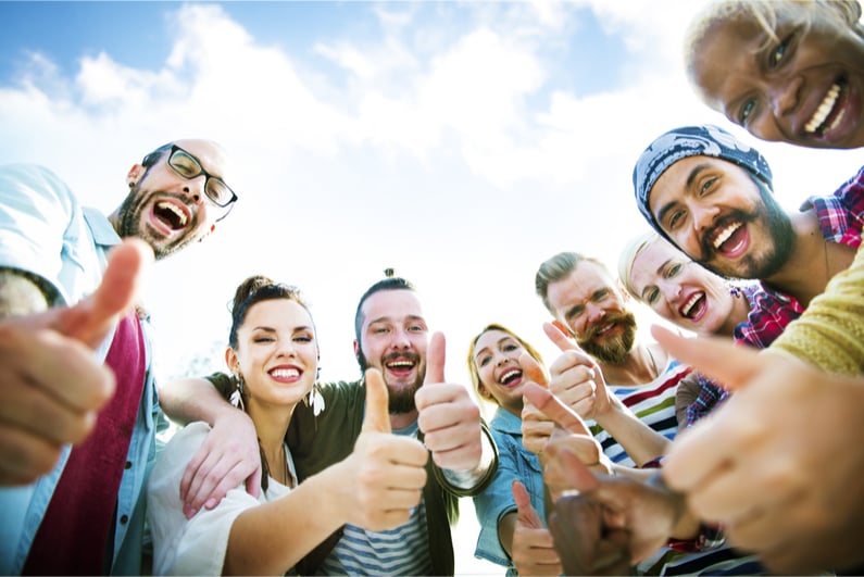 A group if friends with their thumbs up