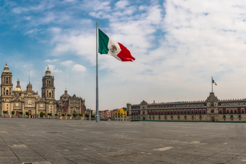 Flag of Mexico against background of Zocalo and Cathedral in Mexico City