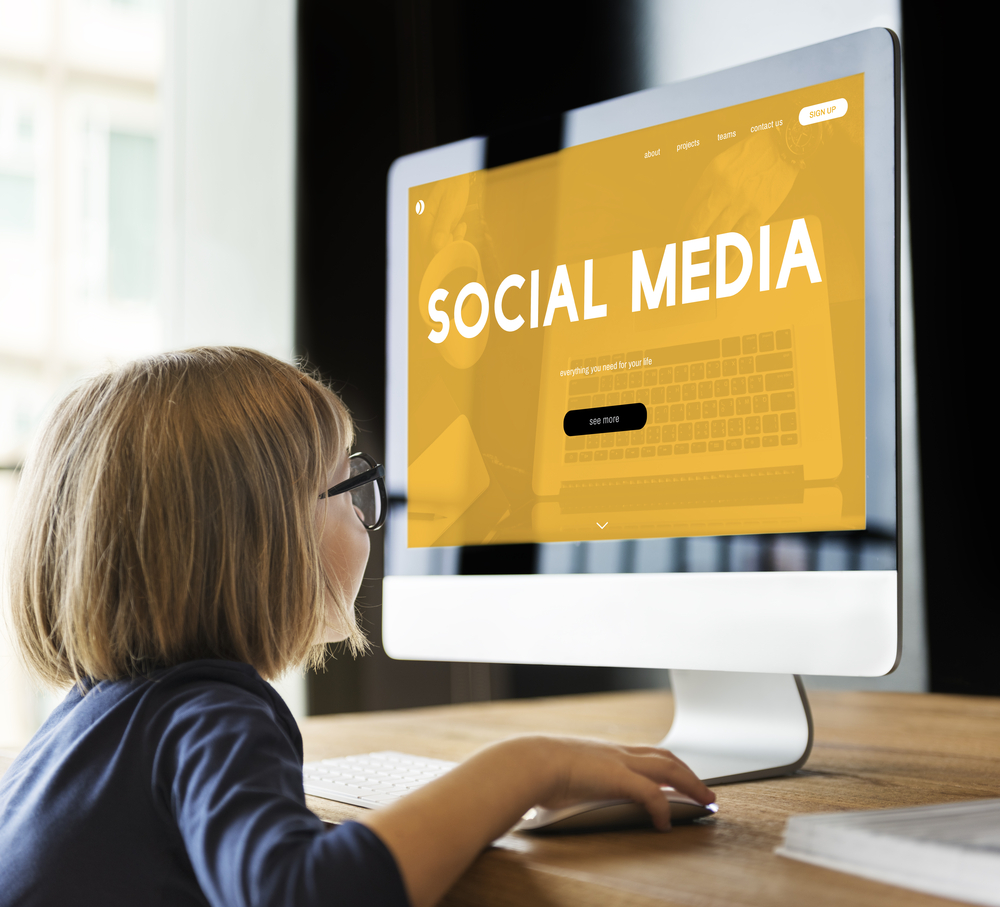 child looking at a computer screen with the words social media