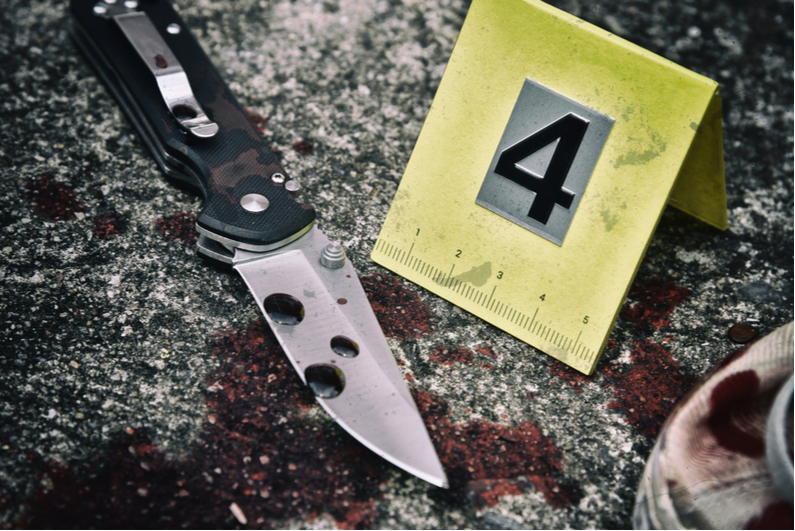 Bloody knife marked as evidence at crime scene