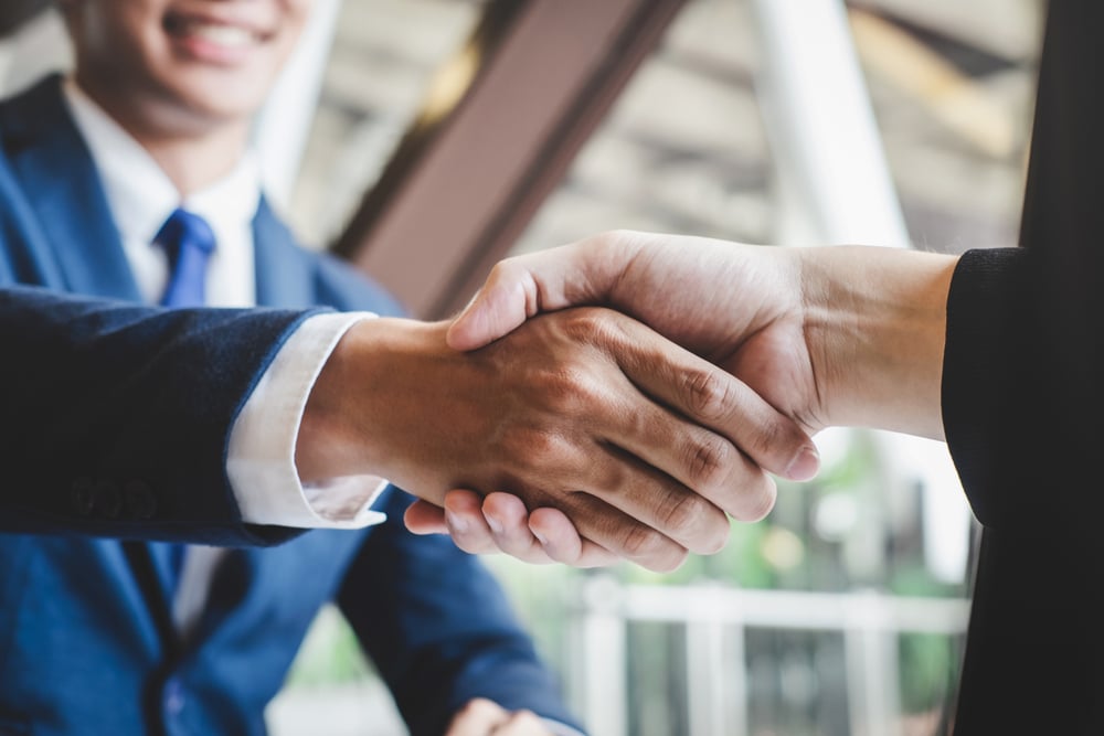 two men in suits shaking hands