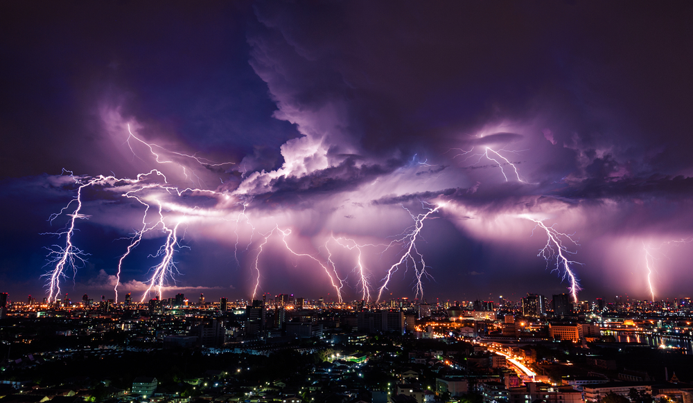 purple lightning over city at night