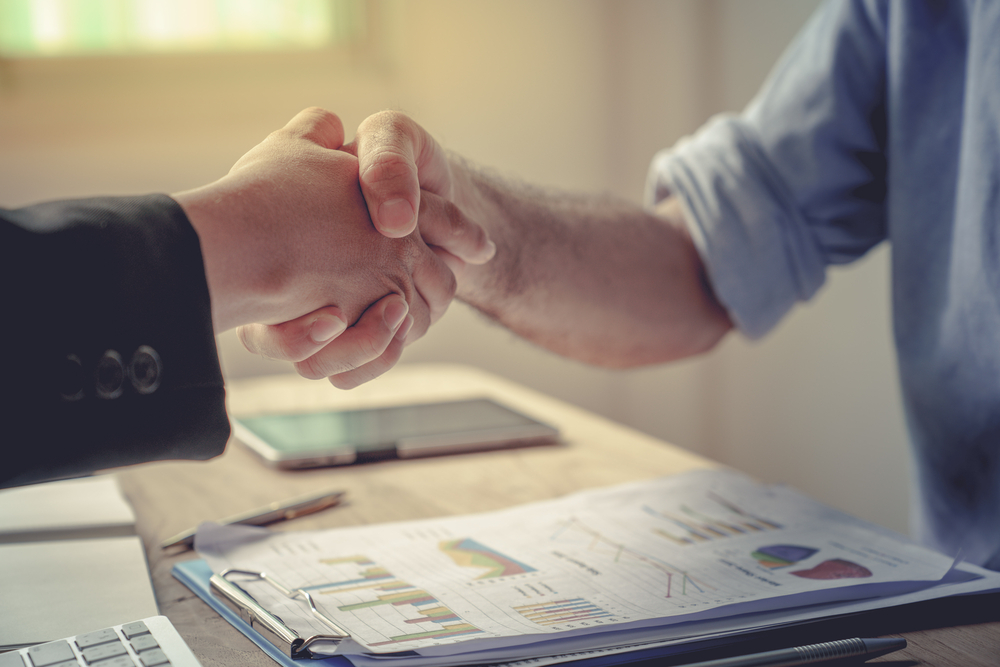 handshake over business and market documents