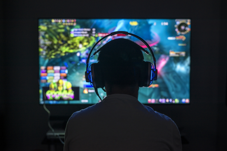 young gamer playing a video game wearing headphone