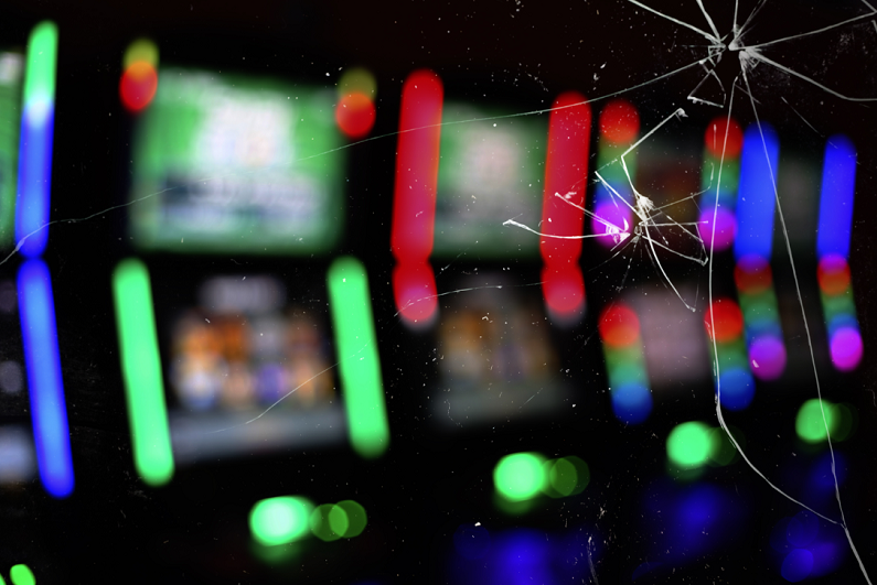 slot machines with glowing lights, under a broken glass