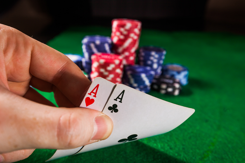 poker chips with two aces on green background