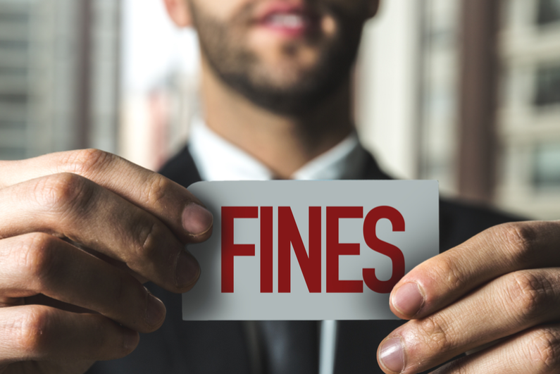 male holding paper with word 'fines' printed