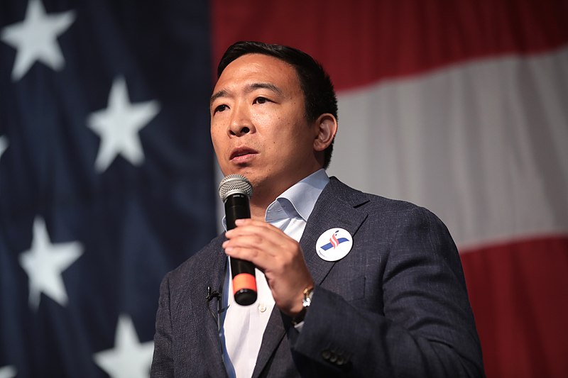 Andrew Yang giving a speech with US flag in the background