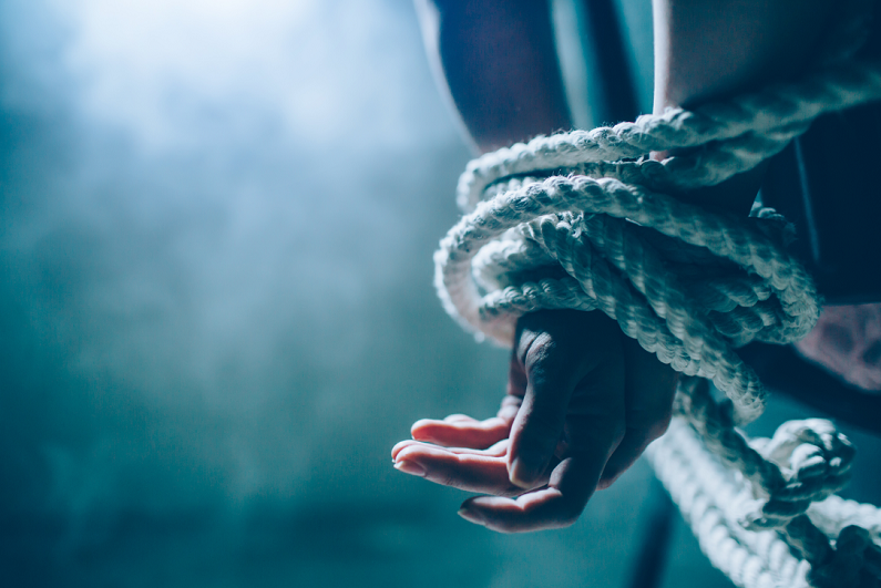 persons hands tied with rope