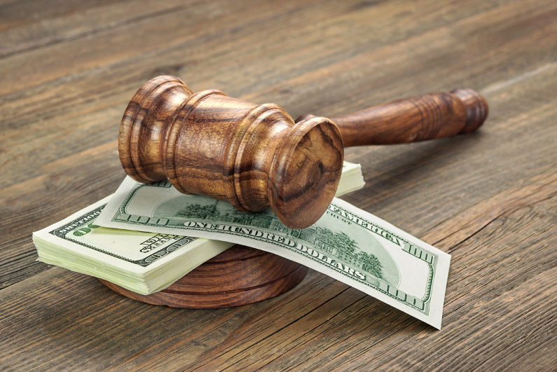 judge's gavel rest on stack of banknotes