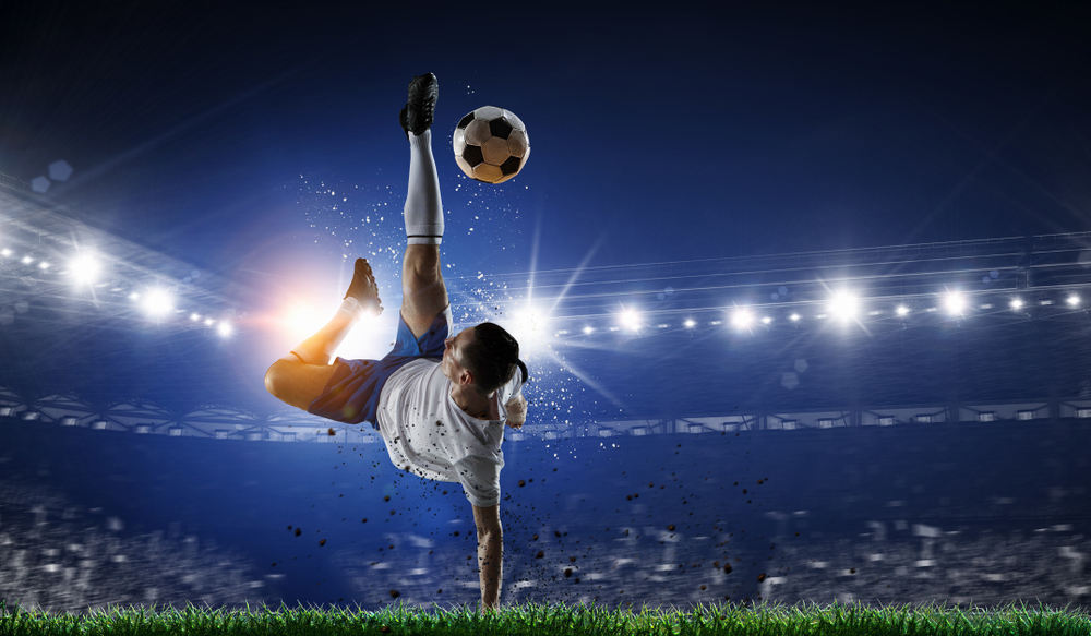 soccer player kicking ball in mid air