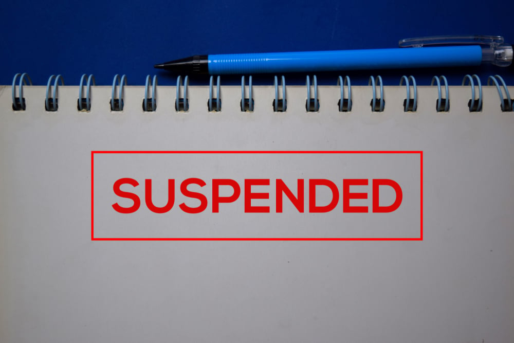 red stamp on notepad reads suspended