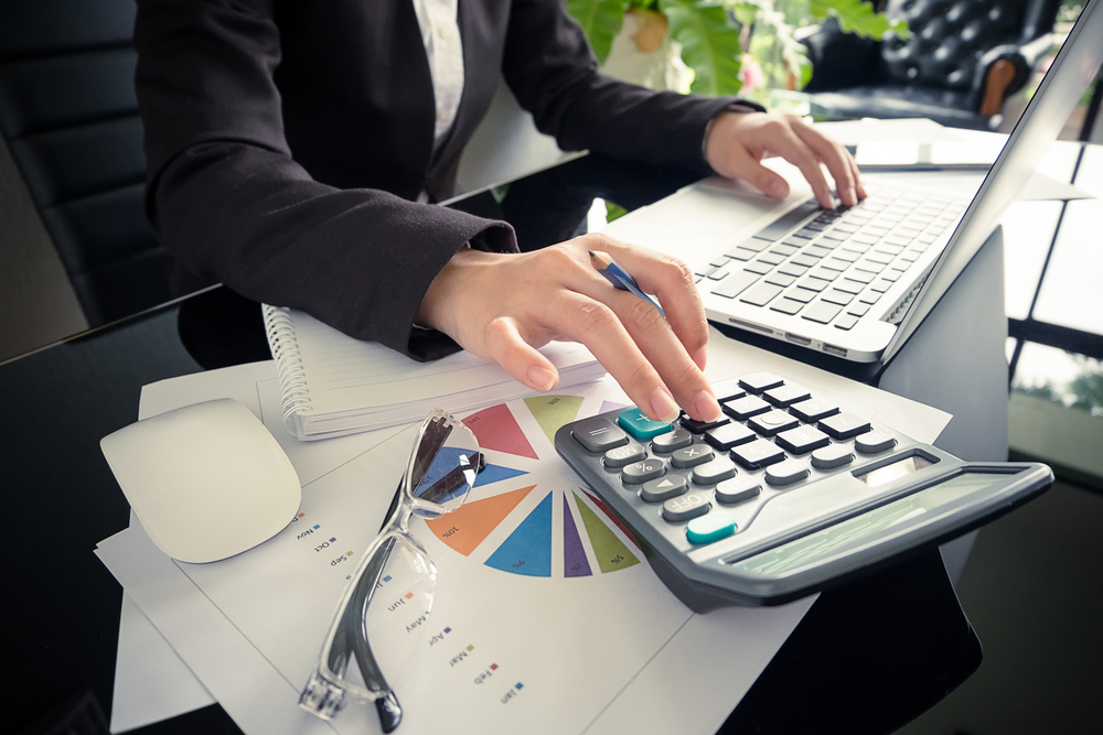 businesswoman using calculator at an office desk