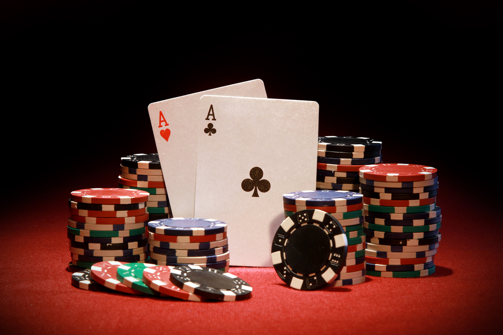poker chips and two Aces on red felt background