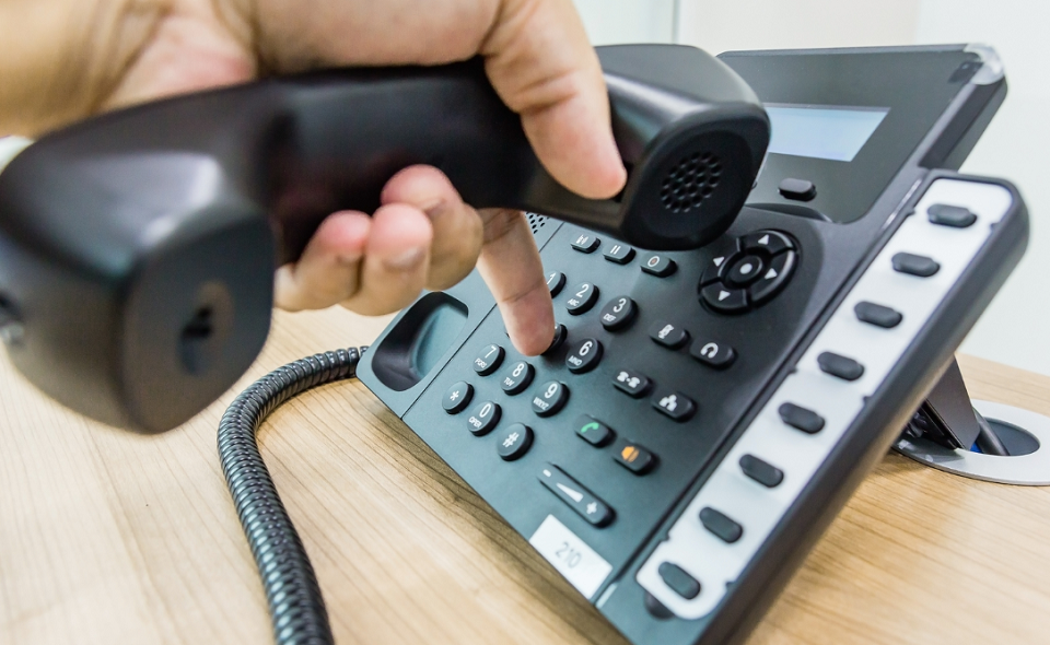 Closeup of male hand holding telephone receiver