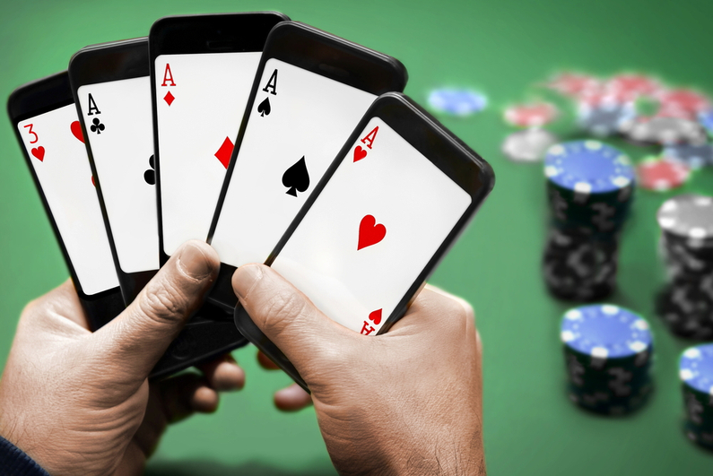 Orang bermain poker, memegang lima smartphone seperti mereka bermain kartu