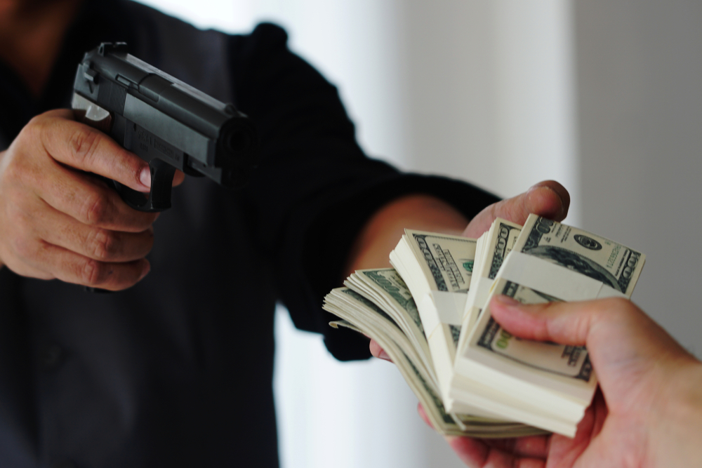 armed robbery sees man with gun taking stacks of money from a victim