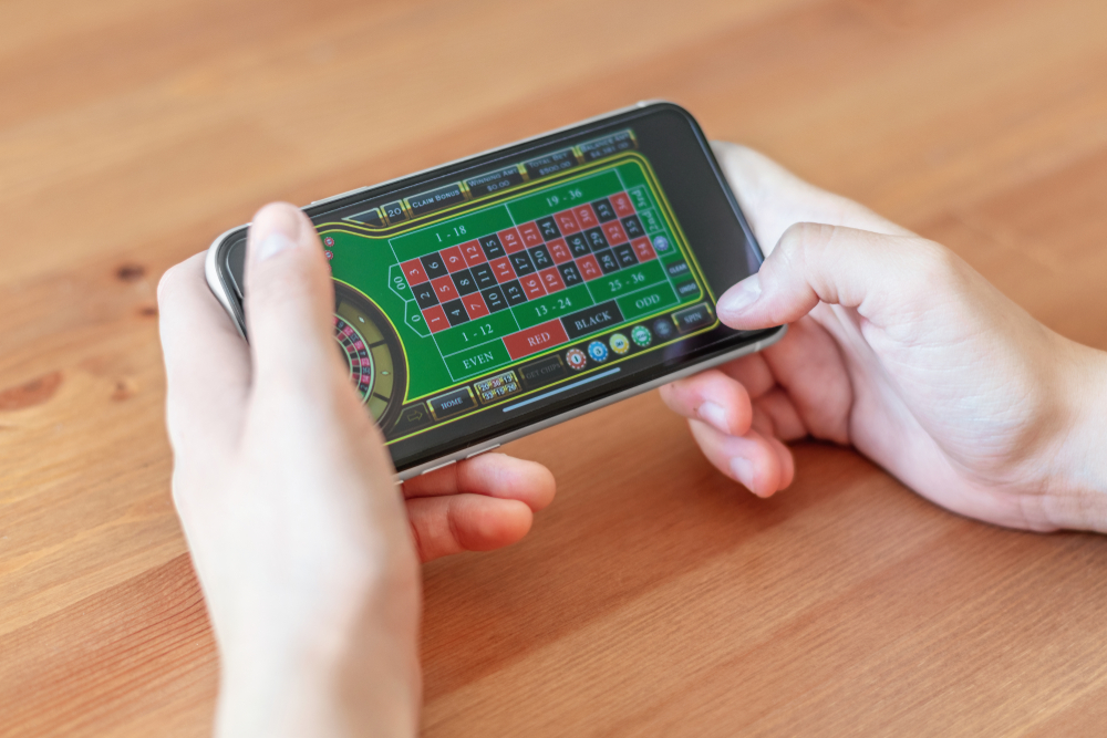 Hands holding smartphone playing roulette app