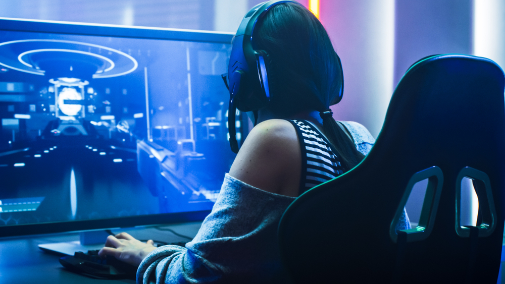 female esports gamer playing at her computer