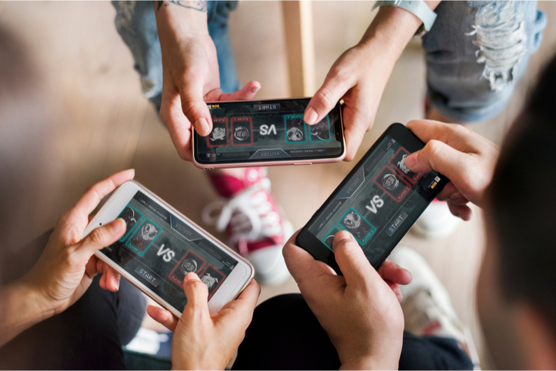 Three friends playing mobile head-to-head games