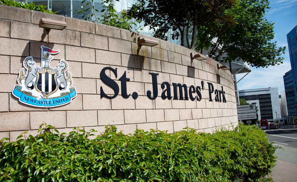 Newcastle United badge and St James' Park lettering on wall outside stadium