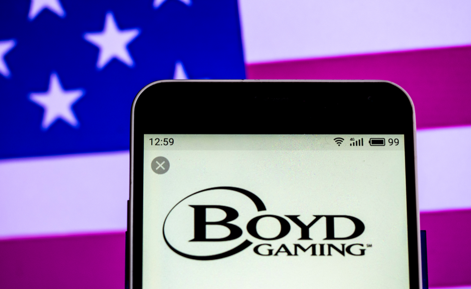 Boyd Gaming logo displayed on smartphone with US flag in background