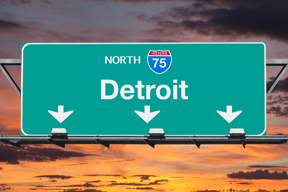 highway sign indicating Detroit against a sunset sky background