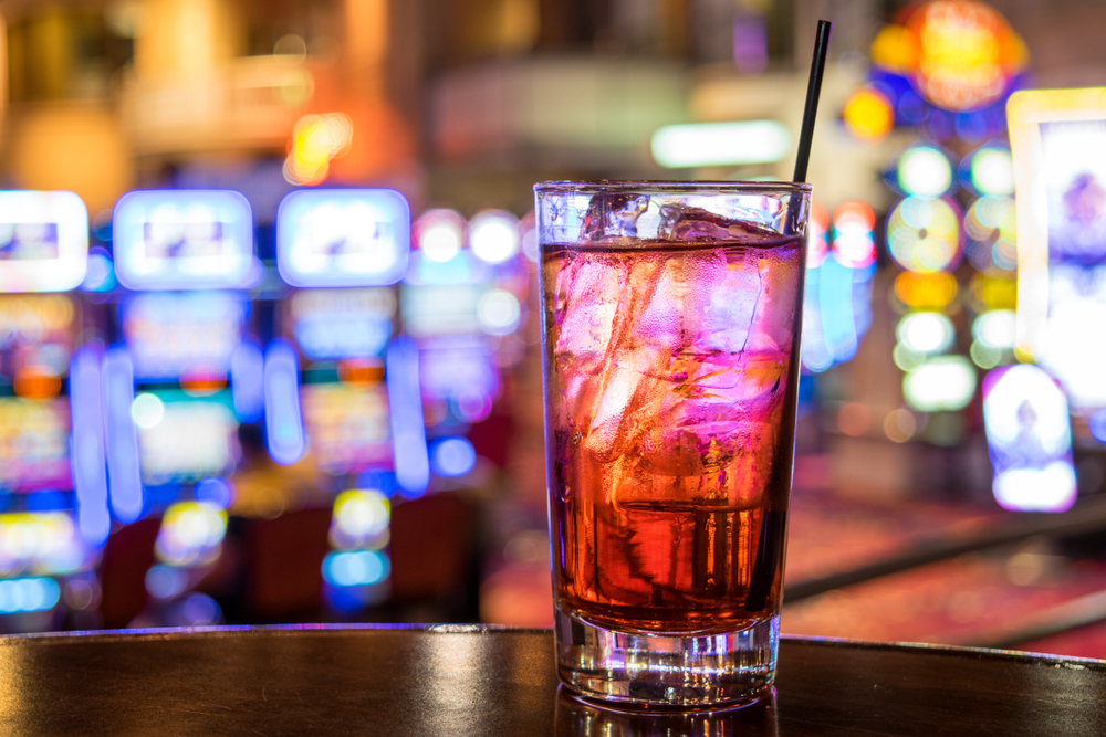 drink at a bar with colorful slots in background