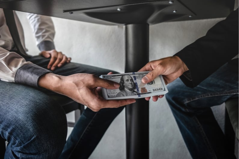 Man accepting a bribe under the table