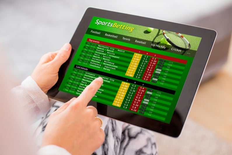 Person using a tablet to bet on sports