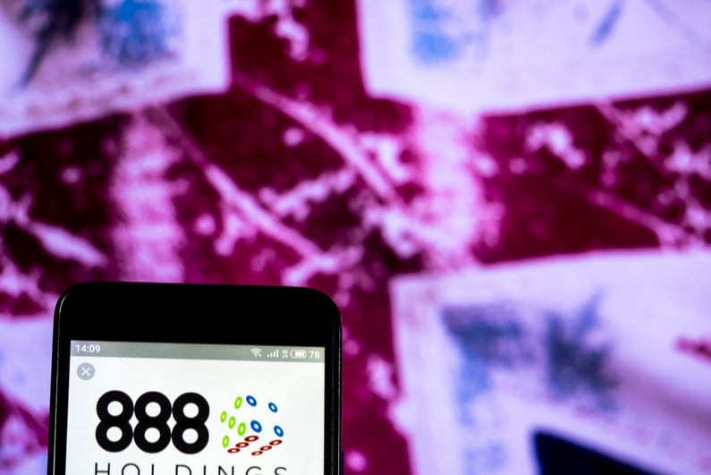 888 Holdings logo on a smartphone in front of UK flag