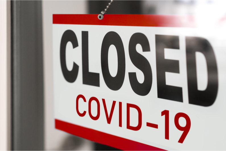 Shop door sign reading "CLOSED COVID-19"