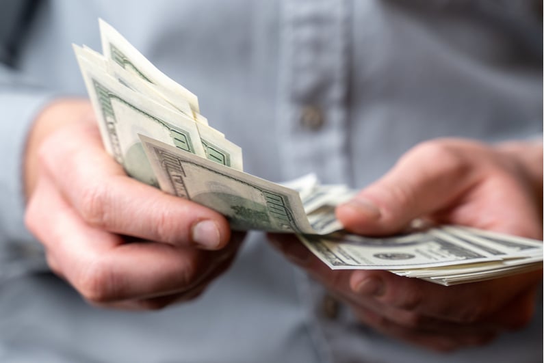 Man fanning out stack of money