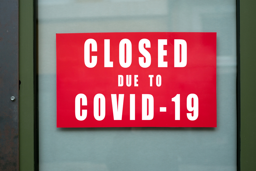 Sign on shop door indicates closure due to COVID-19