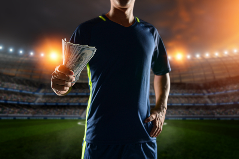 soccer player holding money