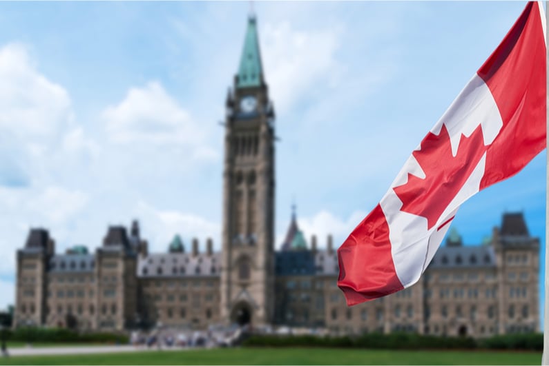 Canadian flag with the Parliament building in the background