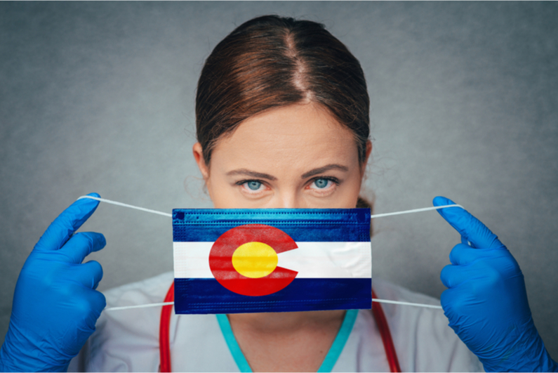 Female doctor putting on Colorado flag mask