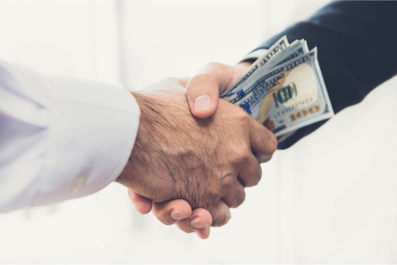 Men exchanging bribe money with a handshake