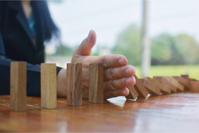 Hand stopping a domino chain