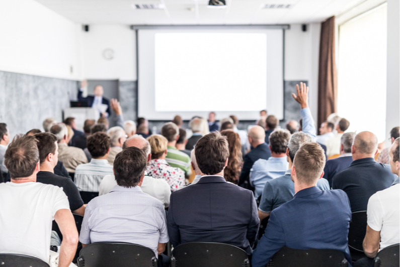 people holding their hands up in a meeting