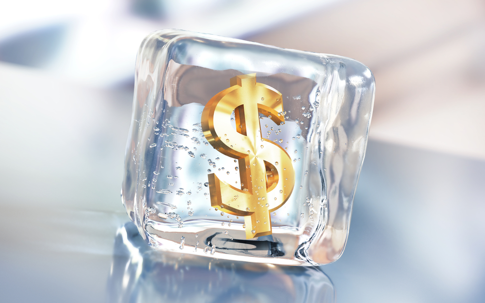 golden dollar sign frozen inside an ice cube