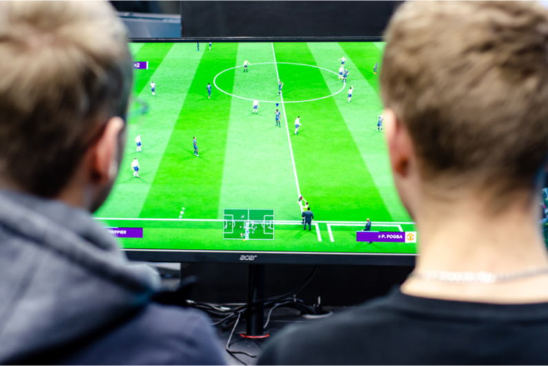 Two teenagers playing FIFA soccer video game