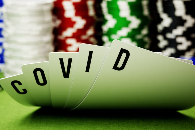 Five poker hole cards spelling out "COVID"